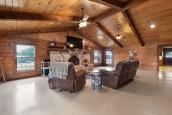 a living room with furniture a fireplace and a flat screen tv