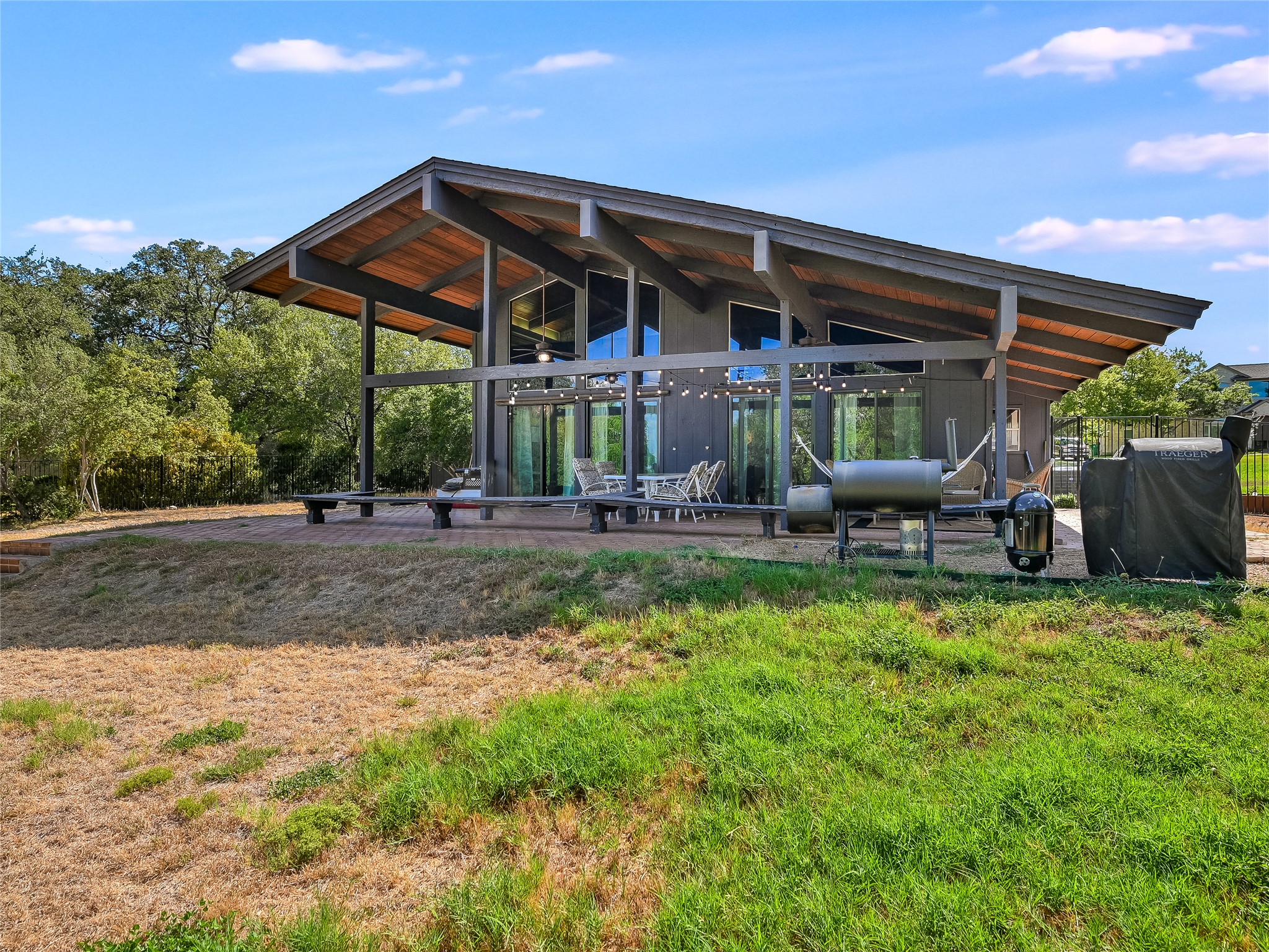 115 Snapper Street Lakeway, TX 78734 - Photo 26 of 30 Cantilevered eaves and glass walls define this striking modern home with an outdoor patio.