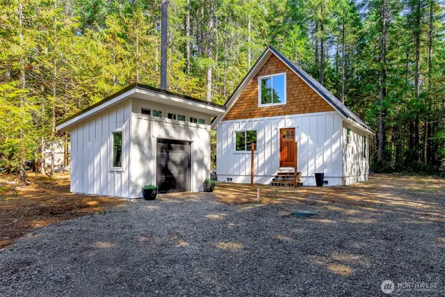 a front view of a house with a large tree