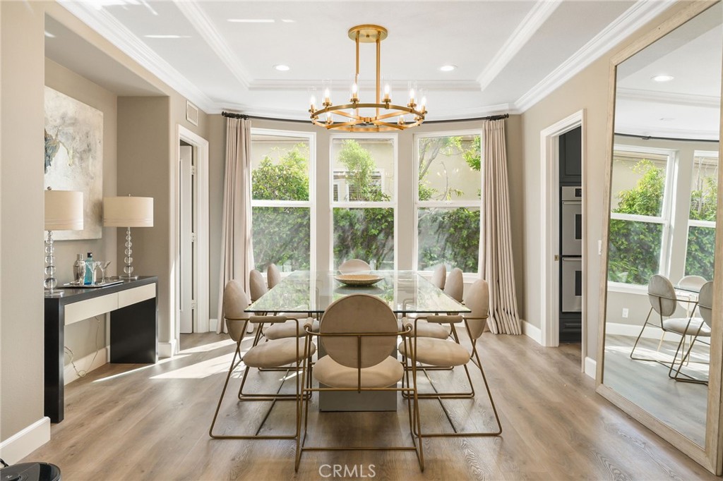 20112 Vía Cellini Porter Ranch, CA 91326 - Photo 11 of 64 a dining room with wooden floor a chandelier a glass table and chairs