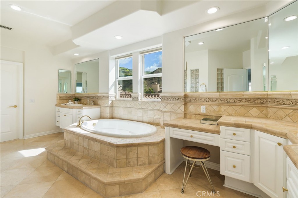 20112 Vía Cellini Porter Ranch, CA 91326 - Photo 32 of 64 a spacious bathroom with a granite countertop toilet sink and mirror