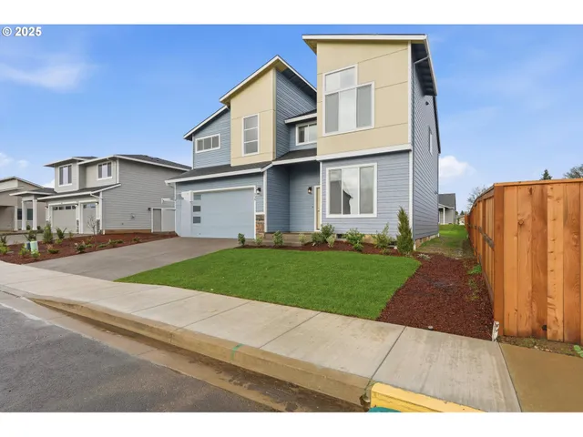 a view of a big house with a street and a car parked in front of it