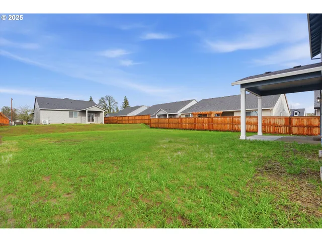 a view of a house with a big yard and large trees