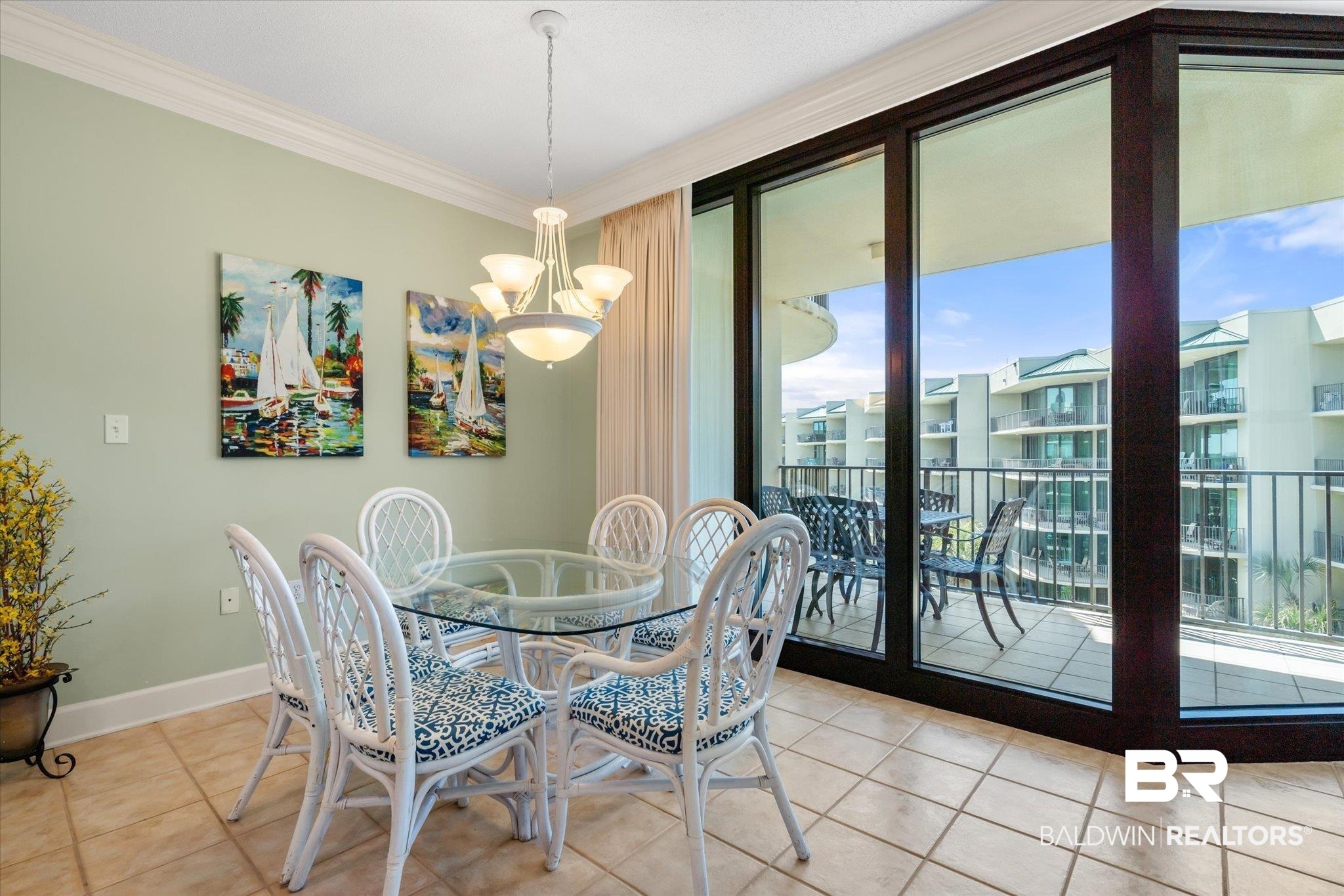 27580 Canal Road, Unit 1423 Orange Beach, AL 36561 - Photo 9 of 34 Tiled dining area featuring a chandelier and ornamental molding.