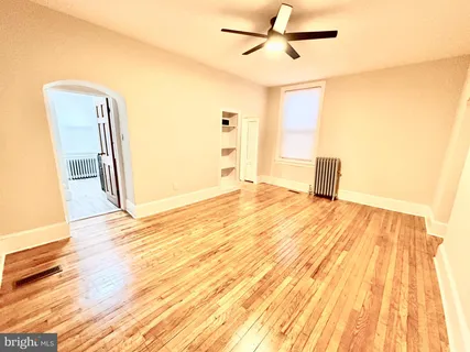 a view of a room with wooden floor and a ceiling fan