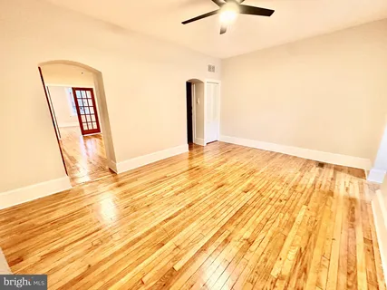 a view of empty room with wooden floor