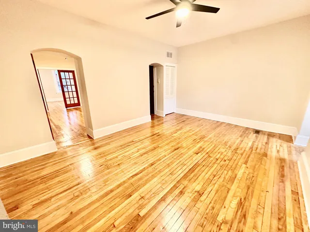 a view of empty room with wooden floor