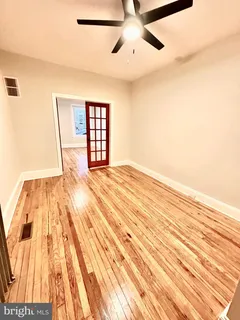 a view of an empty room with wooden floor