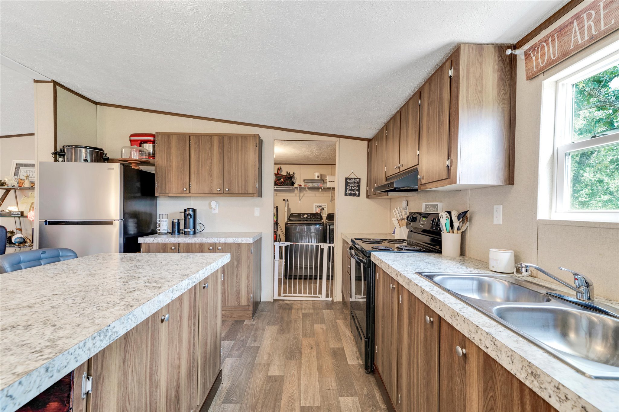 2755 Washburn Road Luling, TX 78648 - Photo 11 of 40 A functional kitchen with wood cabinetry and light countertops, offering ample workspace for daily tasks.