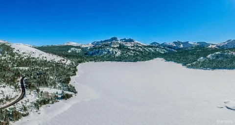 a view of a dry yard with mountains in the background