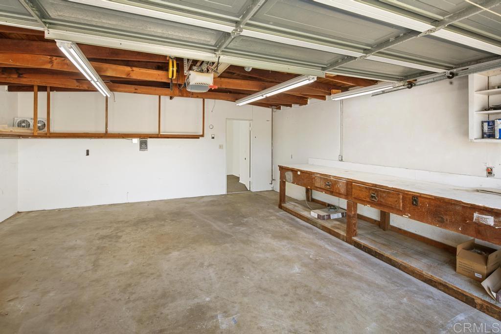 5199 El Arbol Drive Carlsbad, CA 92008 - Photo 29 of 57 2 car garage with workbench and bonus storage shelving