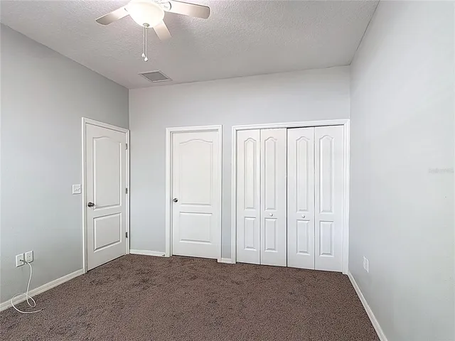 an empty room with a ceiling fan