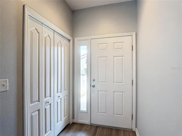 an empty room with wooden floor and entryway