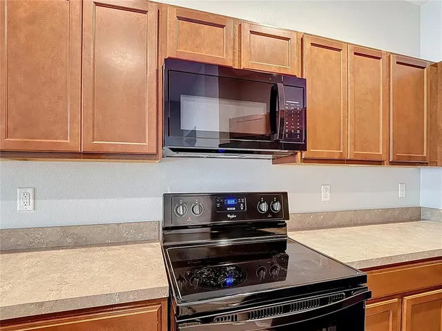 a kitchen with wooden cabinets and a stove top oven