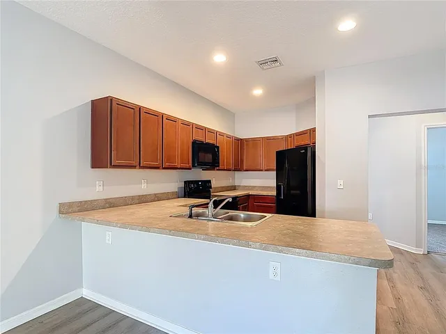 a kitchen with stainless steel appliances granite countertop a sink refrigerator and microwave