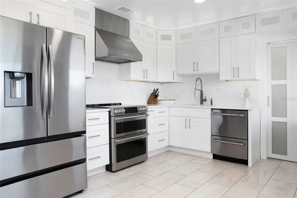 a kitchen with white cabinets and white appliances