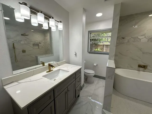 a bathroom with a double vanity sink a toilet a mirror and shower