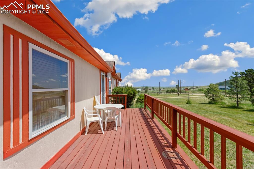 12155 South Mesa View Road Larkspur, CO 80118 - Photo 11 of 16 a view of balcony with wooden floor and outdoor seating