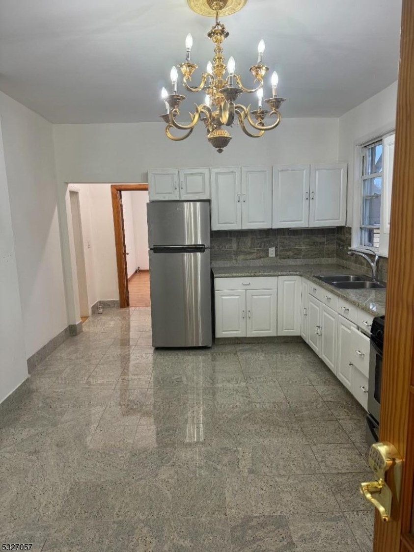 a kitchen with a refrigerator a sink cabinets and microwave