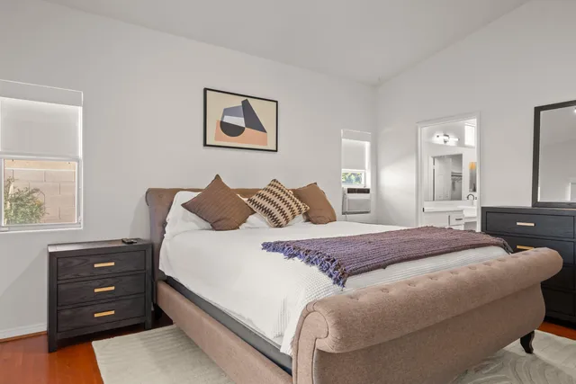 a bedroom with a large bed and a chandelier