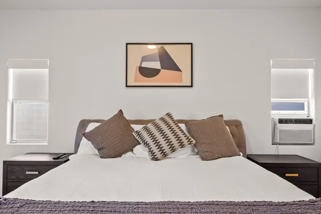 a bedroom with a bed and a potted plant