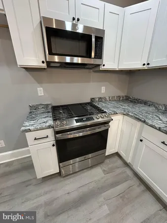 a kitchen with stainless steel appliances granite countertop a stove and a microwave