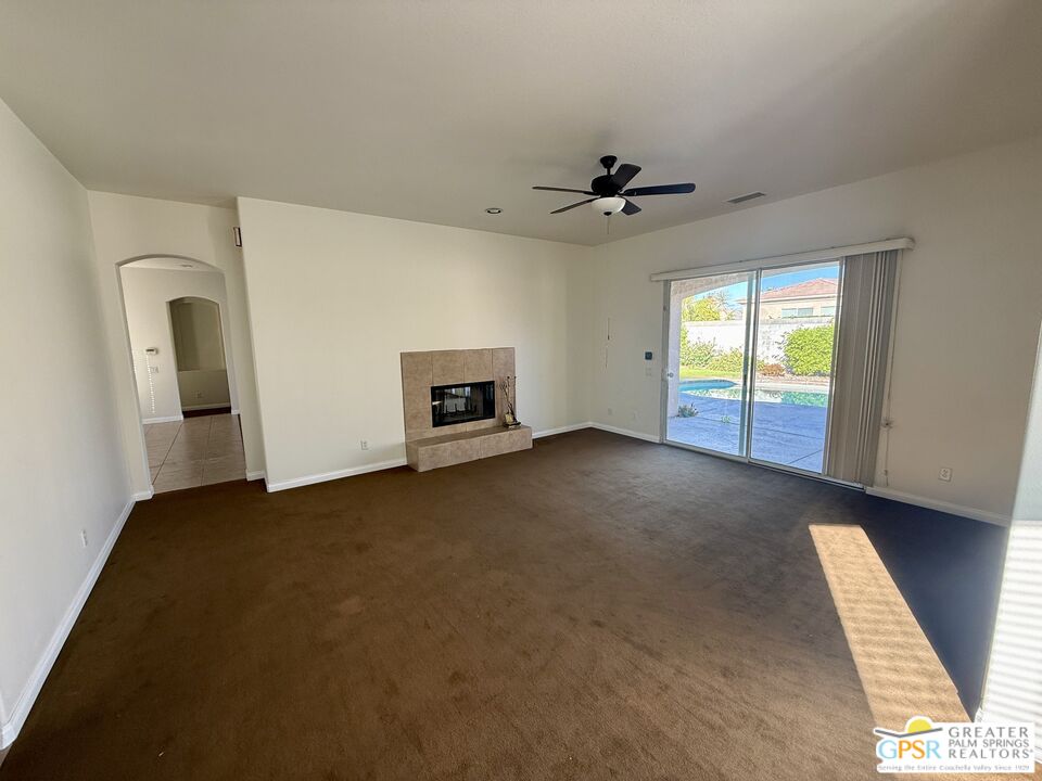 26 Bollinger Road Rancho Mirage, CA 92270 - Photo 4 of 15 a view of an empty room with a fireplace and a window