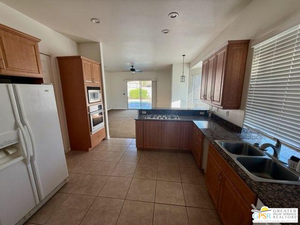26 Bollinger Road Rancho Mirage, CA 92270 - Photo 6 of 15 a kitchen with granite countertop a refrigerator and a sink