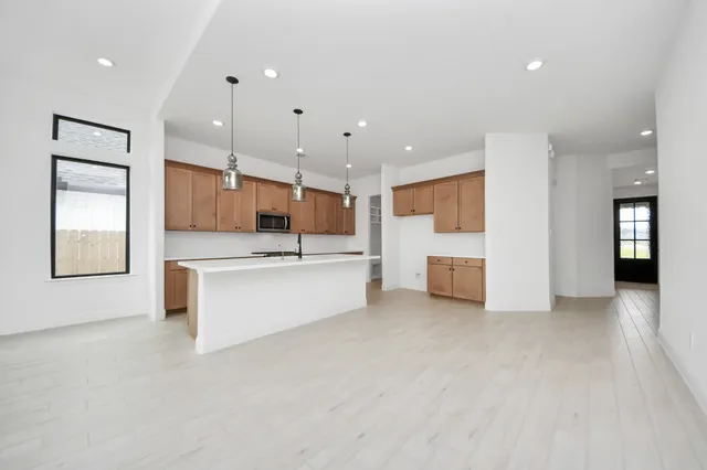 a large kitchen with a large counter top stainless steel appliances and cabinets