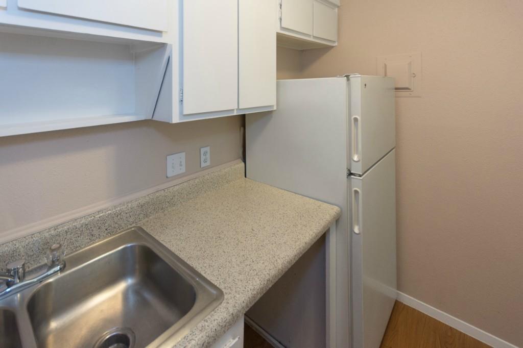 400 West 34th Street, Unit 102 Austin, TX 78705 - Photo 2 of 10 Kitchen with freestanding refrigerator and white cabinets