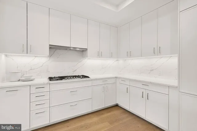 a kitchen with kitchen island a stove a table and chairs
