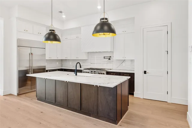 a kitchen with stainless steel appliances a sink a stove a refrigerator and window