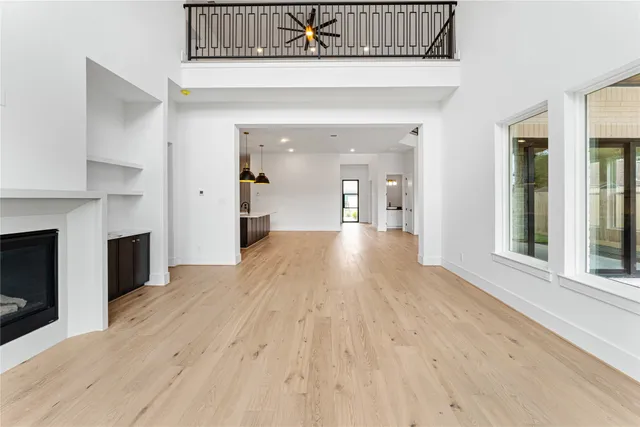 a view of a living hall with wooden floor and a fireplace