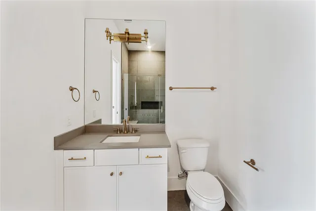 a bathroom with a granite countertop toilet sink and mirror