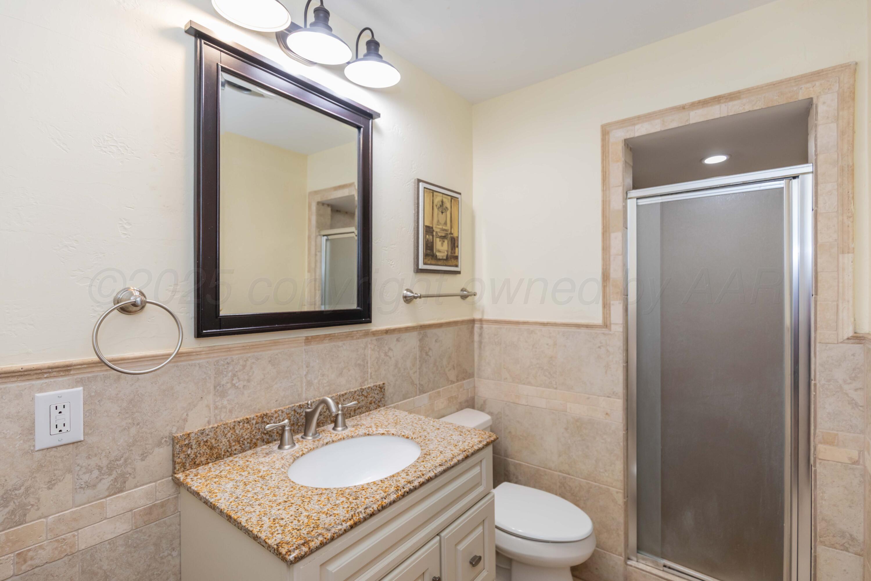 Amarillo Sunset Portfolio Amarillo, TX 79109 - Photo 172 of 279 a bathroom with a granite countertop sink a toilet and a mirror