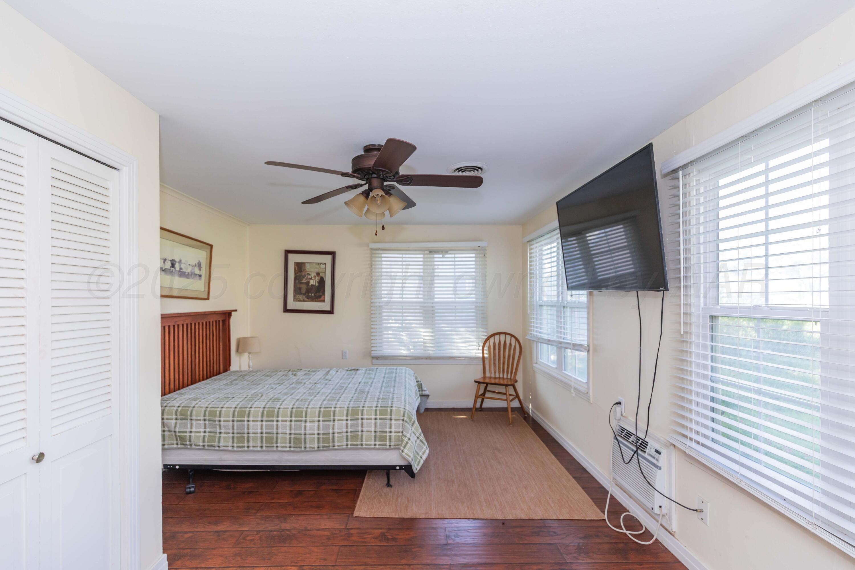 Amarillo Sunset Portfolio Amarillo, TX 79109 - Photo 251 of 279 a bedroom with a bed and wooden floor