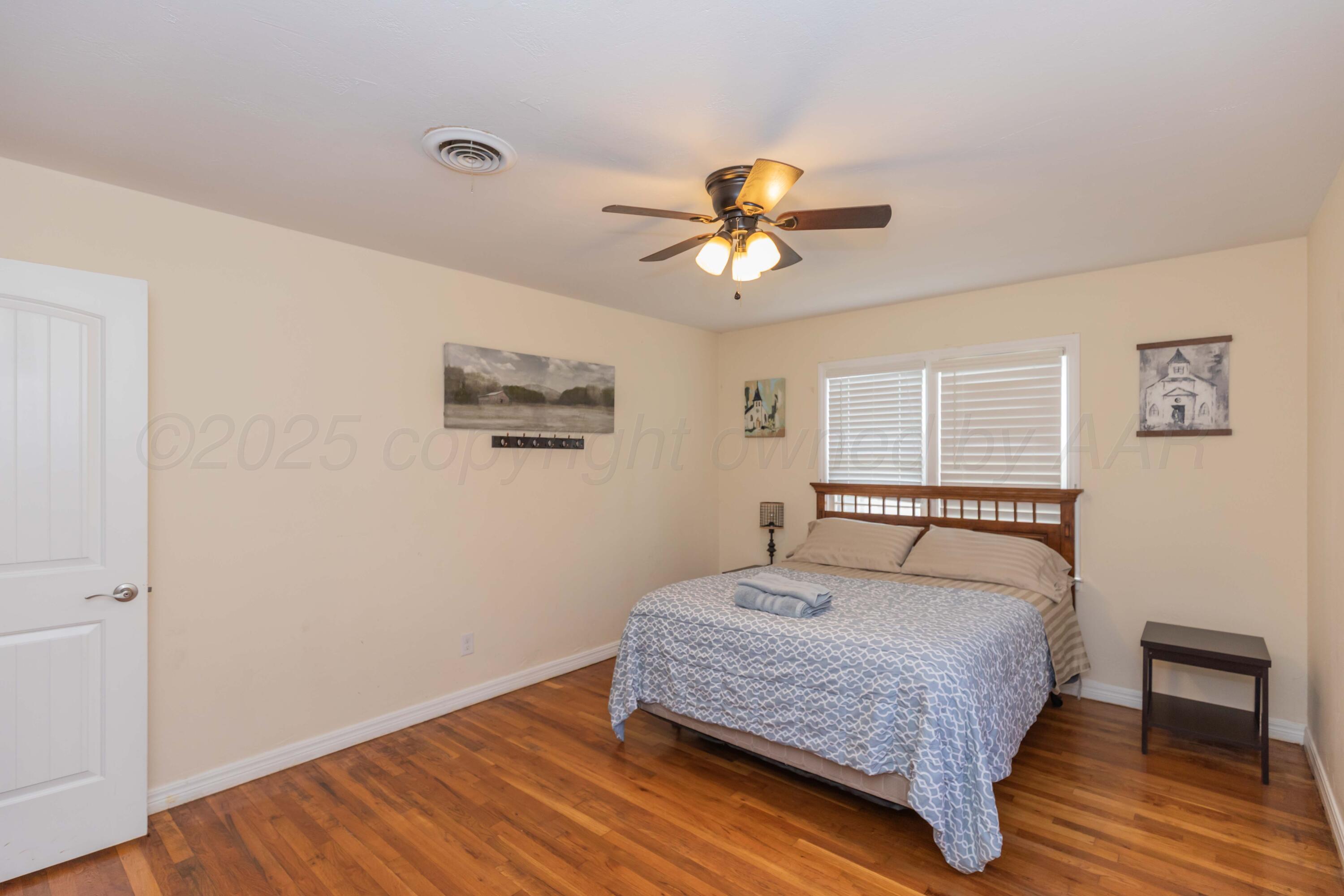 Amarillo Sunset Portfolio Amarillo, TX 79109 - Photo 66 of 279 a bedroom with a bed a dresser and wooden floor