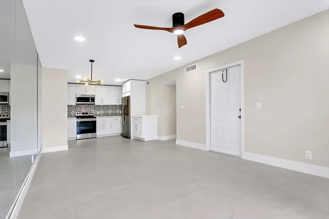 an empty room with closet and windows