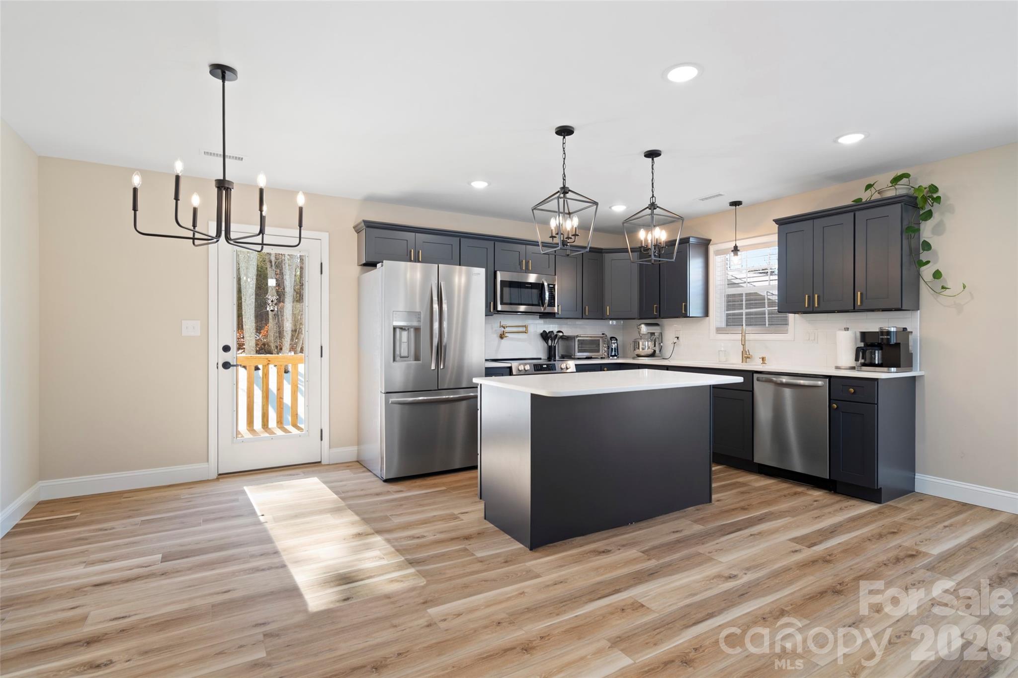 5961 Charlie Little Road Granite Falls, NC 28630 - Photo 2 of 29 a kitchen with refrigerator a sink and a wooden floor