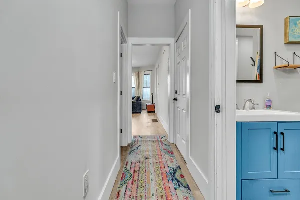 a view of a hallway with wooden floor and closet