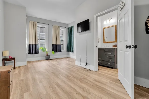 a view of a livingroom with wooden floor and a flat screen tv