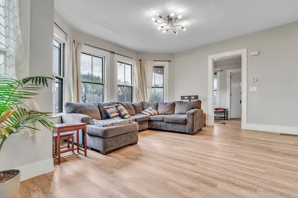 a living room with furniture and a chandelier