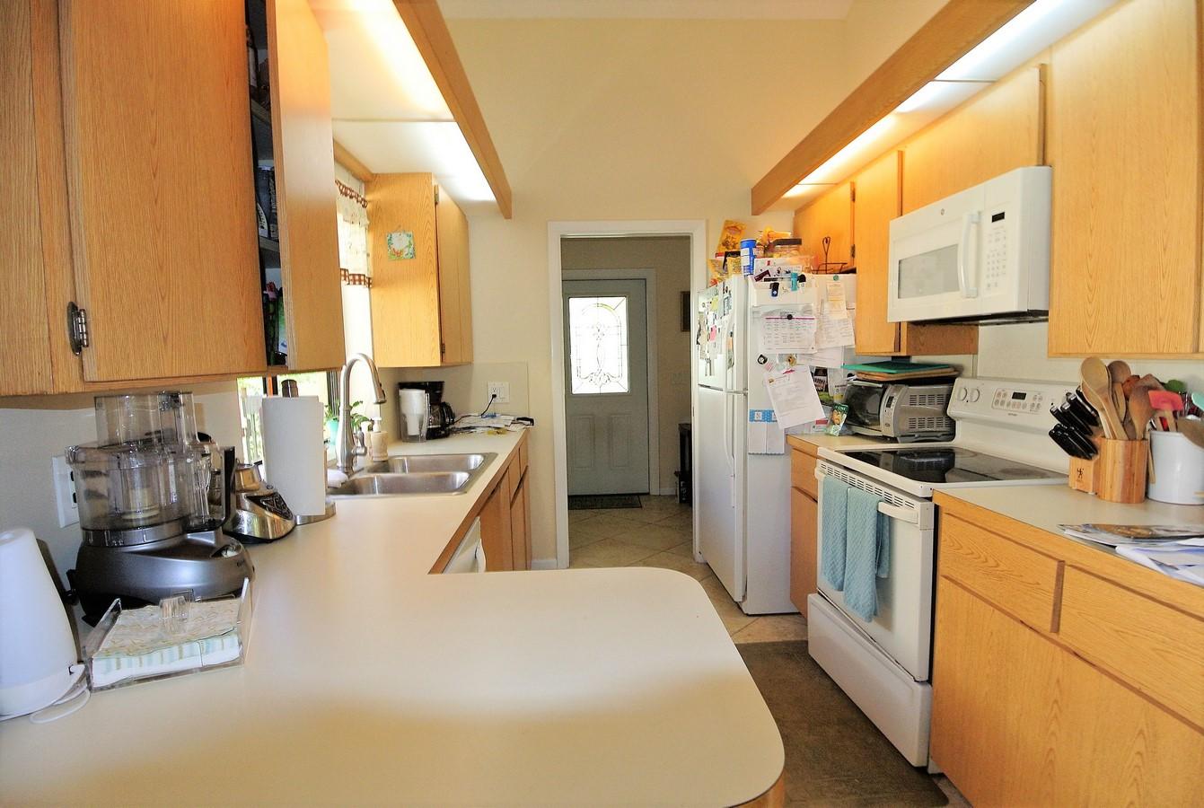200 Ridge Road Jupiter, FL 33477 - Photo 6 of 18 a kitchen with sink refrigerator and cabinets