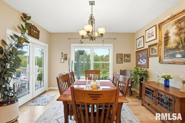 a dining room with furniture a chandelier and wooden floor