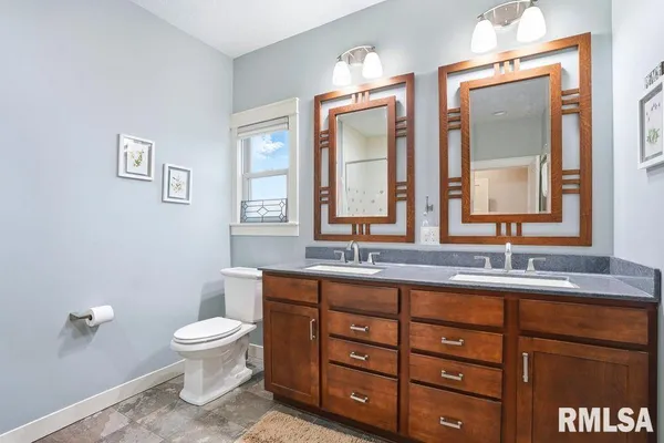 a bathroom with a toilet a sink and mirror
