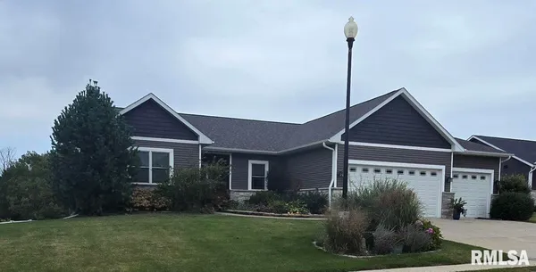 a view of a house with a yard and potted plants