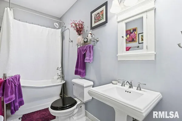 a white toilet sitting next to a bathroom sink and tub