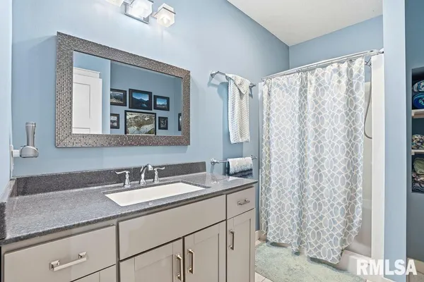 a bathroom with a granite countertop sink and a mirror