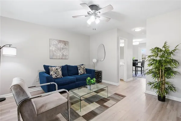a living room with furniture a chandelier and a potted plant