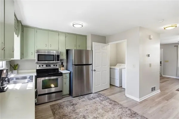 a kitchen with a refrigerator and a stove top oven